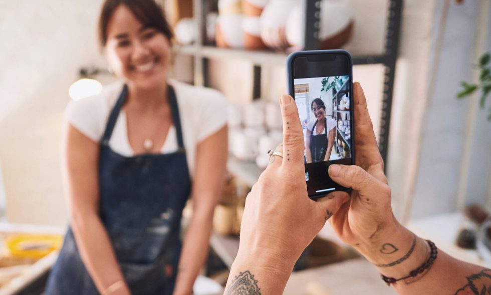 Small business owner takes picture for Instagram page to boost followers.